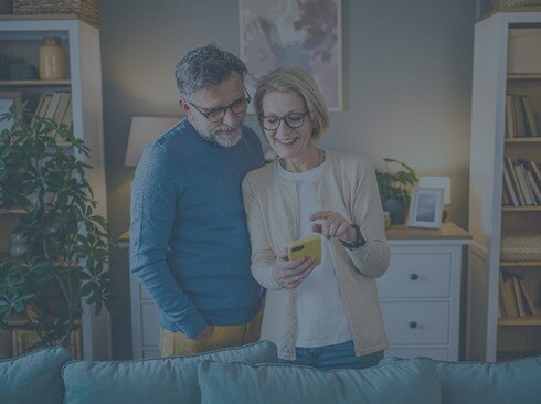 Two people in a home looking at a phone